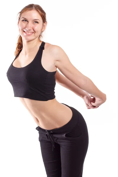 Женская фитнес-модель, тренирующаяся в студии с гантелями и выполняющая упражнения на растяжках и подтяжках на коврике . — стоковое фото