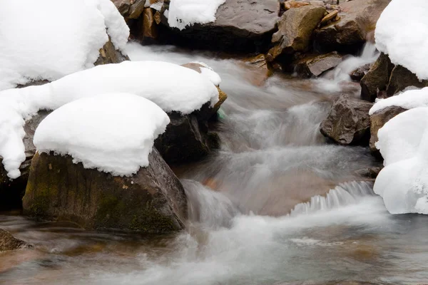 Küçük, aktif bir şelale. Temiz dağ deresi, karlı kış manzarası, vahşi yaşam geçmişi