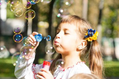 Çimlerin üzerinde gülen mutlu kız. Gülümseyen çocuk dışarıda