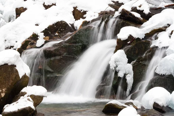 A small active waterfall. Clean mountain stream, snowy winter landscape, wildlife background — Stock Photo, Image