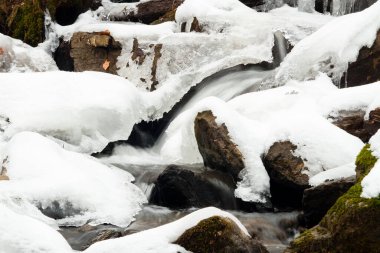 Küçük, aktif bir şelale. Temiz dağ deresi, karlı kış manzarası, vahşi yaşam geçmişi
