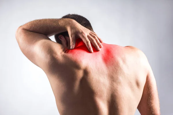 adamın gri arka plan üzerine bir vücut ağrısı. Kırmızı nokta