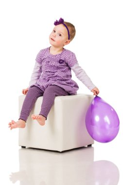 Küçük kız bir balonla oynuyor.