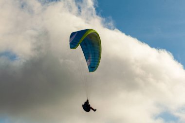 Yaz günü bulutlar üzerinde uçan Yamaçparaşütü