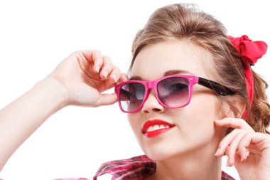 Coquettish girl in silk dress and glasses licks her finger and holds martini