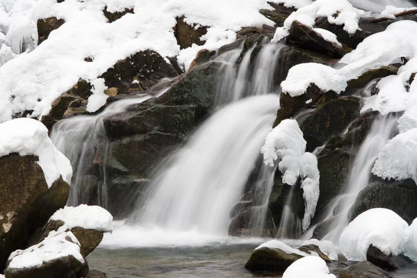 一个小的活动瀑布。 清澈的山溪，雪白的冬季风景，野生动物背景 — 图库照片