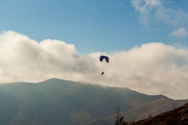 Yaz günü bulutlar üzerinde uçan Yamaçparaşütü