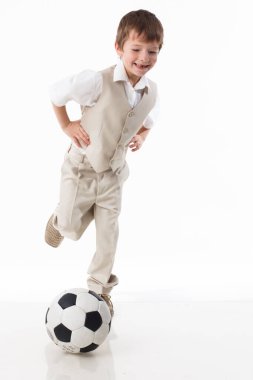 Sportif bir çocuk bir futbol topuyla oynuyor. Sağlıklı yaşam tarzı, spor ve spor anlayışı. Beyaz arkaplanda izole.