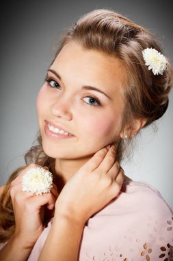 Çiçek açan bir bahçede çekici bir genç kızın güzel portresi. Hasır şapkalı ve beyaz elbiseli kıvırcık saçlı kadın. Yeni sezon konsepti