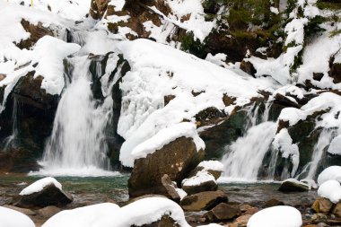 Küçük, aktif bir şelale. Temiz dağ deresi, karlı kış manzarası, vahşi yaşam geçmişi