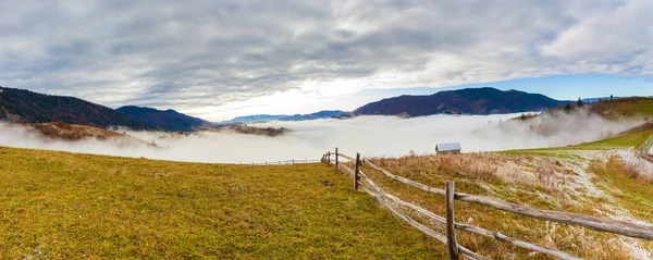 Carpathian mountains, Ukraine. Beautiful foggy mountain landscape with a wooden fence in the mountains in vintage colors. — Fotografia de Stock