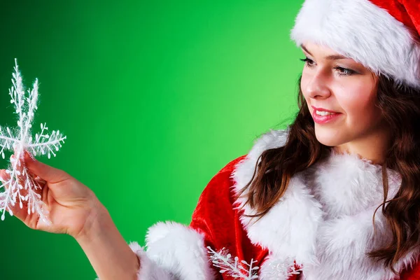 Красивая эмоциональная девушка с длинными волосами, одетая как Санта Клаус, позирует на зеленом хромированном фоне. — стоковое фото