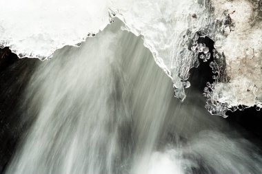 Küçük, aktif bir şelale. Temiz dağ deresi, karlı kış manzarası, vahşi yaşam geçmişi