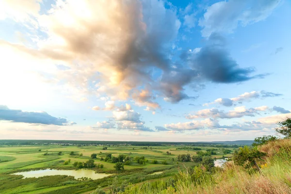 Ein wunderschönes Tal mit einem Fluss, blauem Himmel mit großen Wolken und strahlender Sonne. Antenne 4K UHD — Stockfoto