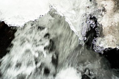 Küçük, aktif bir şelale. Temiz dağ deresi, karlı kış manzarası, vahşi yaşam geçmişi