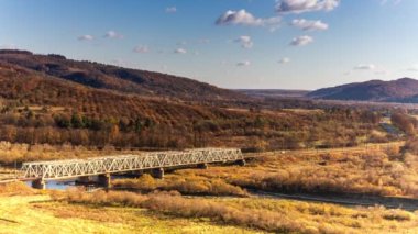 Ukrayna 'daki Stryi Nehri üzerindeki demiryolu köprüsünün havadan görüntüsü. Nehir boyunca uzanan güzel bir kırmızı demiryolu köprüsü, tepeler arasında muhteşem bir vadide yer alıyor..