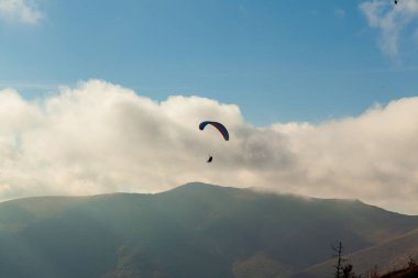 Yaz günü bulutlar üzerinde uçan Yamaçparaşütü