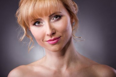 Güzel bir kadın yüzü. Gri üzerinde genç bir stüdyo resmi.