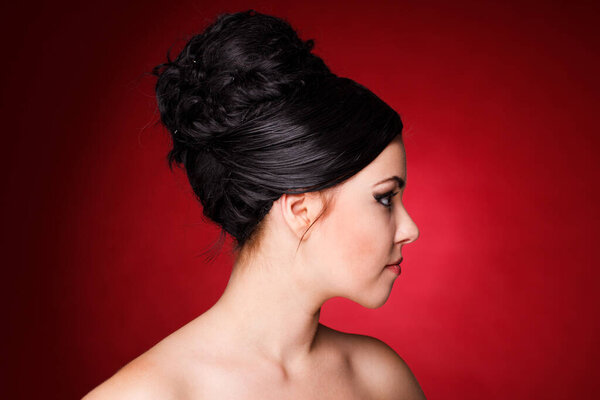 Portrait of a sexy woman with black hair on a red background.