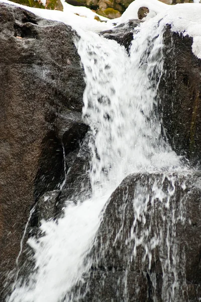 一个小的活动瀑布。 清澈的山溪，雪白的冬季风景，野生动物背景 — 图库照片