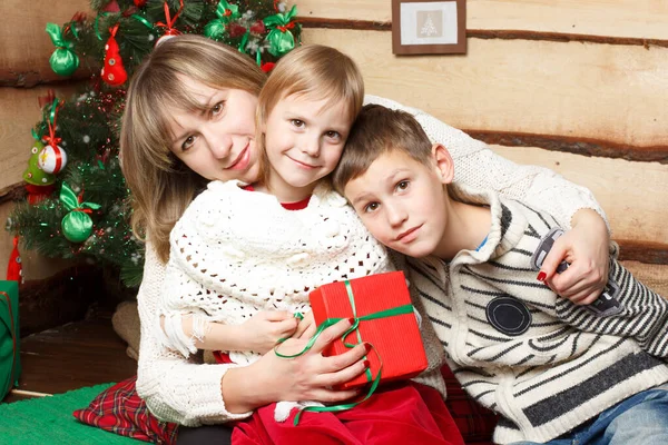 Madre felice e due suoi figli vicino a un abete decorato per Natale — Foto Stock