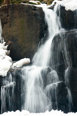 Küçük, aktif bir şelale. Temiz dağ deresi, karlı kış manzarası, vahşi yaşam geçmişi