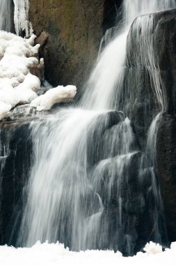 Küçük, aktif bir şelale. Temiz dağ deresi, karlı kış manzarası, vahşi yaşam geçmişi