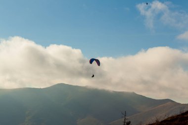 Yaz günü bulutlar üzerinde uçan Yamaçparaşütü