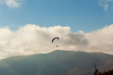 Yaz günü bulutlar üzerinde uçan Yamaçparaşütü