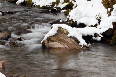 Küçük, aktif bir şelale. Temiz dağ deresi, karlı kış manzarası, vahşi yaşam geçmişi