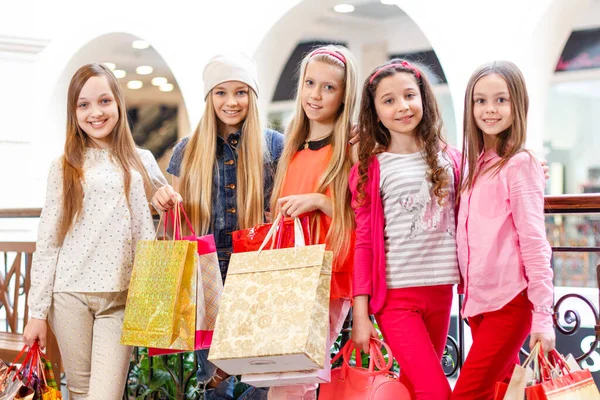 Criança elegante em boina francesa e casaco moderno. Menina com sacos de compras. Tempo de primavera. Tendência do outono. Dia das compras. vida feliz moderna. Rapariga. Look de moda infantil. espaço de cópia. vida moderna . — Fotografia de Stock