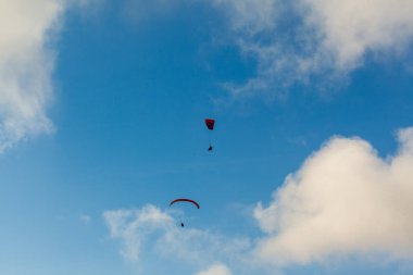 Yaz günü bulutlar üzerinde uçan Yamaçparaşütü