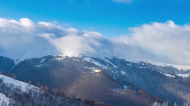 Yüksek Dağlar Tepeleri 'nin Manzaralı Hava Görüntüsü. Güneşli Kış Günü 'nde destansı manzara. Blue Sky, Fog ve Snow 'la hızlandırılmış video. Ukrayna 'daki Karpat Dağı' nın 4K Arka plan Çekimi