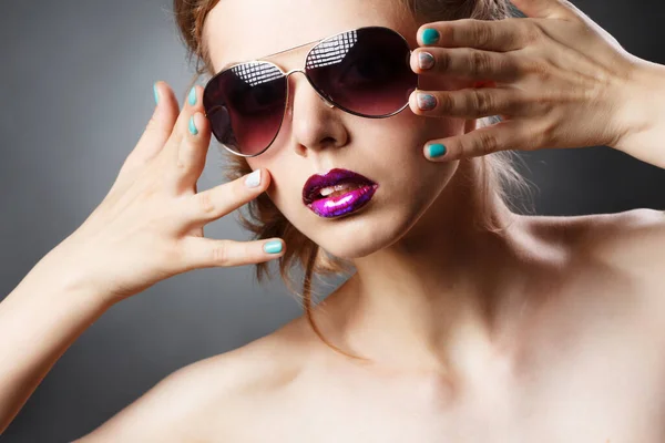 Una chica joven y hermosa con maquillaje oscuro unta lápiz labial oscuro en sus labios . — Foto de Stock