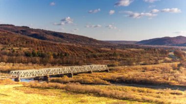 Ukrayna 'daki Stryi Nehri üzerindeki demiryolu köprüsünün havadan görüntüsü. Nehir boyunca uzanan güzel bir kırmızı demiryolu köprüsü, tepeler arasında muhteşem bir vadide yer alıyor..