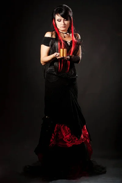 Menina bonita com cabelo vermelho, vestindo um longo vestido de renda de flamenco preto e vermelho gótico com espartilho preto. ajoelhado no chão. isolado em fundo branco. — Fotografia de Stock