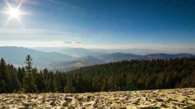 Parçalı bulutlu bir çöl gündoğumunun zamanı bir dağ geçidinden izleniyor. HDR 'de vurulmuş. Ön plandaki kayaları aşan hipersüratli döngü hareketini içerir.