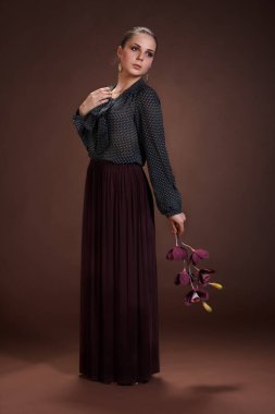 Kahverengi arka planda gülümseyen çekici kadın portresi