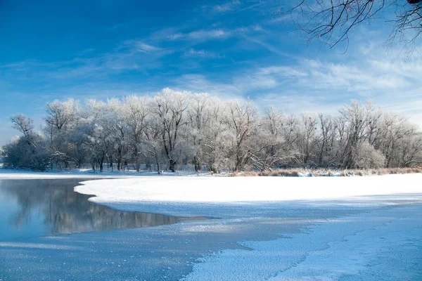 Photo the snow-covered river did not freeze in winter.The river flows in winter. Snow on the branches of trees. Reflection of snow in the river. Huge snowdrifts lie on the Bank of the stream. — Stock Photo, Image