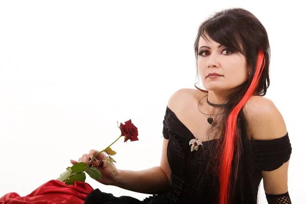 Gyönyörű fiatal lány vörös hajjal, hosszú gótikus fekete-piros flamenco csipke köntöst visel fekete fűzővel. Letérdelt a földre. elszigetelt fehér háttér. — Stock Fotó
