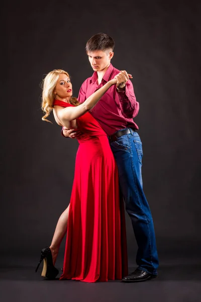 赤いドレスの女と男の衣装でポーズをとっています。 — ストック写真