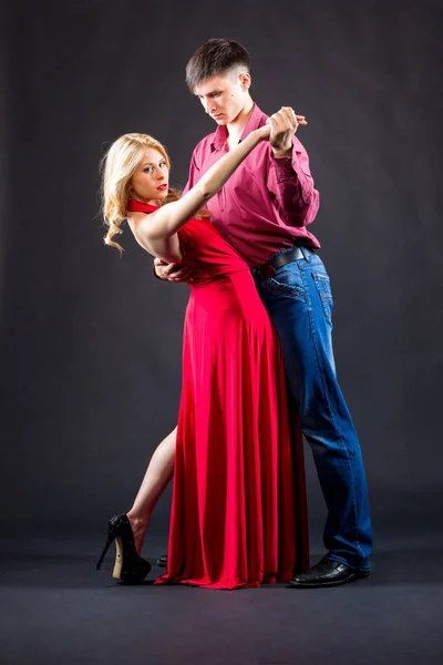 Woman in a red dress and man in a costume are posing Stock Picture