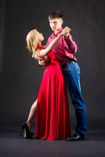 In een kostuum man en vrouw in een rode jurk zijn poseren — Stockfoto