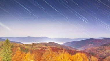 Gece gökyüzünde hareket eden yıldız izlerinin zaman atlamalı. Yaz aylarında dağ sırası üzerinde dönen Samanyolu galaksisi
