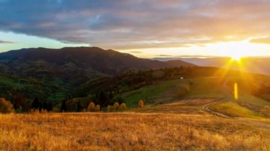 Gün batımında gökyüzüne karşı dağların manzarası. Dağların üzerinde muhteşem bir günbatımı