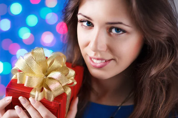 Gift box woman hold against gray background. Close up Isolated portrait of young smiling model. — Stock Photo, Image