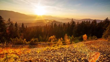 Parçalı bulutlu bir çöl gündoğumunun zamanı bir dağ geçidinden izleniyor. HDR 'de vurulmuş. Ön plandaki kayaları aşan hipersüratli döngü hareketini içerir.
