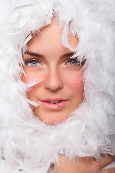 Модное женское лицо, окруженное белыми перьями — стоковое фото