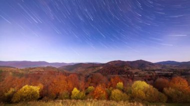 Gece gökyüzünde hareket eden yıldızların zaman çizelgesi. Samanyolu Galaksisi yaz mevsiminde dağ sırasının üzerinde döner. Yüksek kaliteli zaman dilimi.