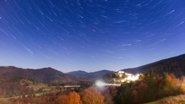 Gece gökyüzünde hareket eden yıldızların zaman çizelgesi. Samanyolu Galaksisi yaz mevsiminde dağ sırasının üzerinde döner. Yüksek kaliteli zaman dilimi.